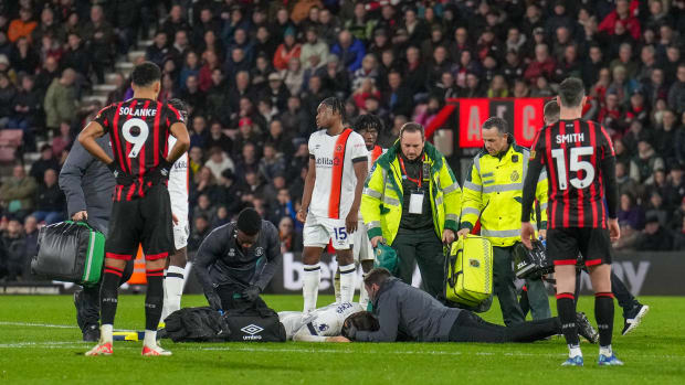 Club medical staff and members of the emergency services pictured treating Tom Lockyer on the field at Bournemouth's Vitality Stadium after the Luton Town captain collapsed during a Premier League game in December 2023
